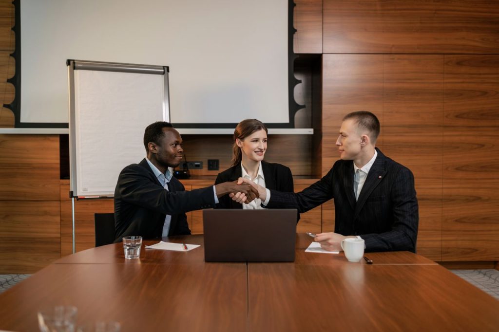 pexels photo 8134006 Diverse business team having a successful meeting and agreement, shaking hands across the table.
